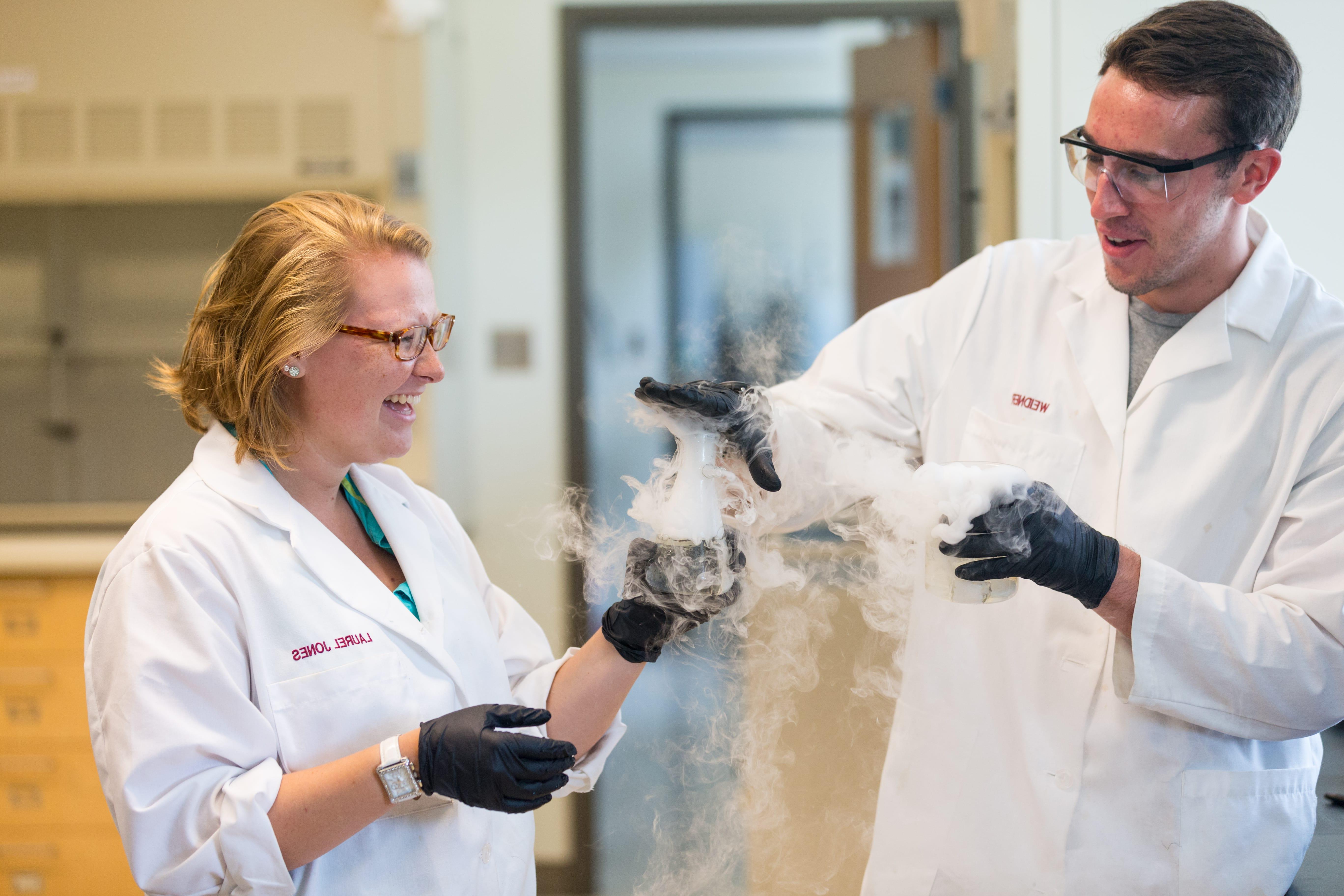 Two John S. Toll Fellows have some fun in the lab for their summer research